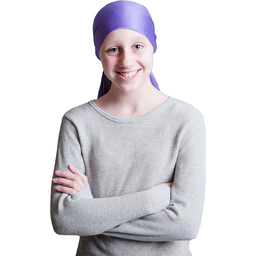 A teenage girl wearing a wrap on her head stands with her arms crossed smiling
