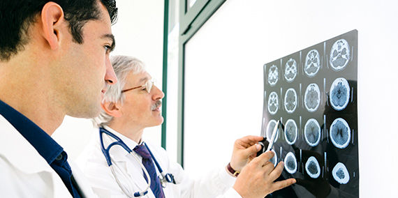 Two doctors examine an MRI scan of a brain