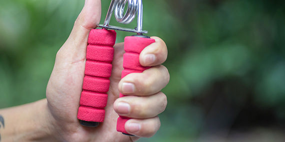 A closeup of a hand using a grip strengthening tool