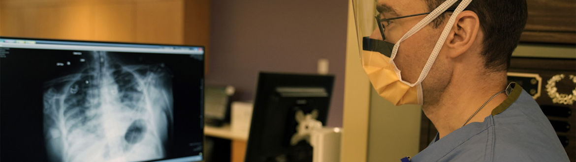 A medical provider reads a chest x-ray on a computer screen