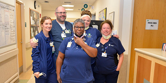 A group of ChristianaCare nurses stands together smiling at the camera