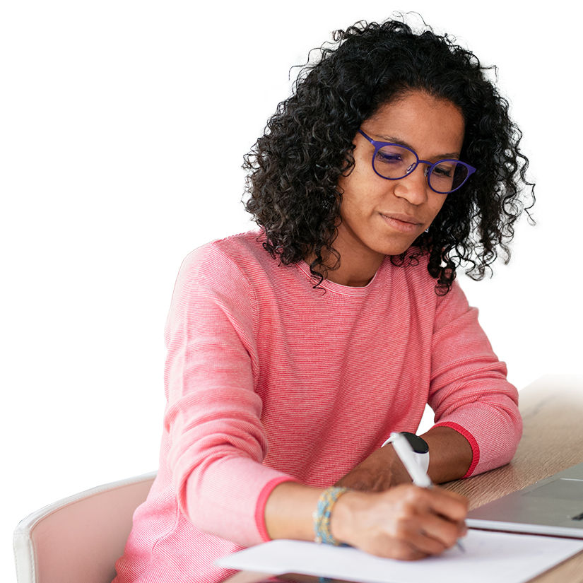 Woman sits at table taking notes