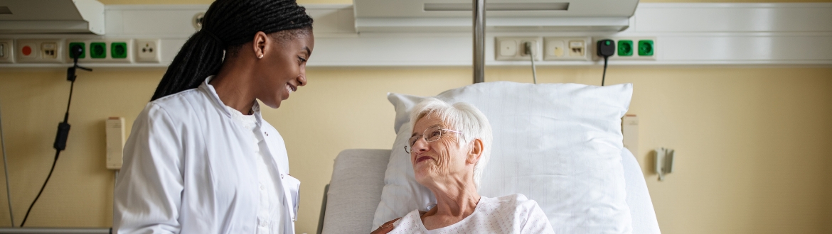 Doctor consoling senior patient during visit