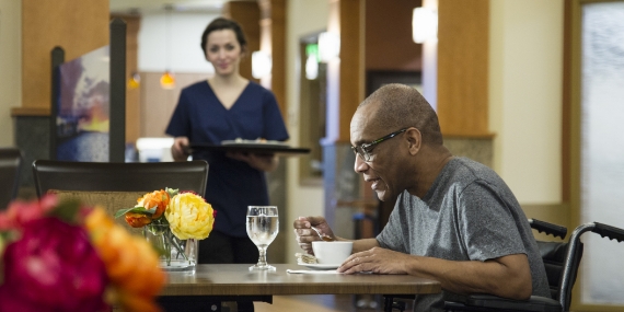 Elderly man eating in hospital canteen