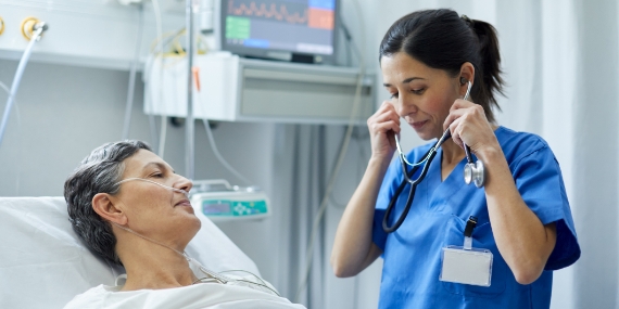 A nurse is putting the stethoscope on her ears to examine a patient