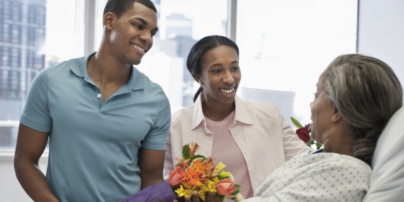 Children bringing mother flowers in hospital