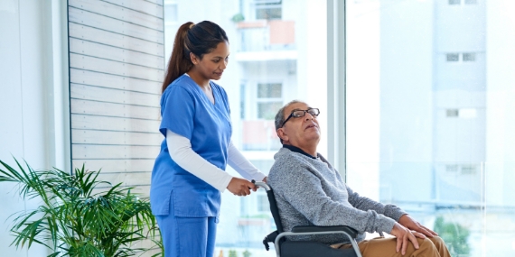 Nurse pushing man in wheelchair