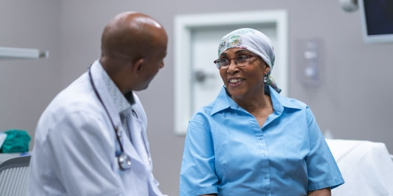 Un médico junto a un paciente oncológico