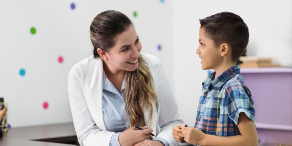 Un psicólogo y un niño pequeño que sonríen entre sí