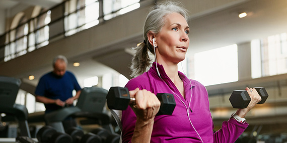 Mujer mayor levantando pesas en el gimnasio