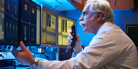 Médico examinando exploraciones en la pantalla de la computadora