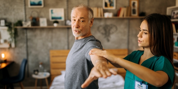 Una enfermera que ayuda a un hombre a estirarse