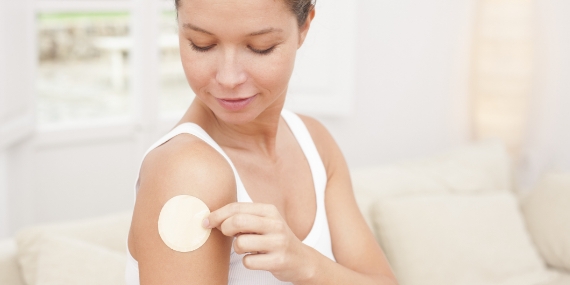 Mujer colocando un parche de nicotina en un brazo
