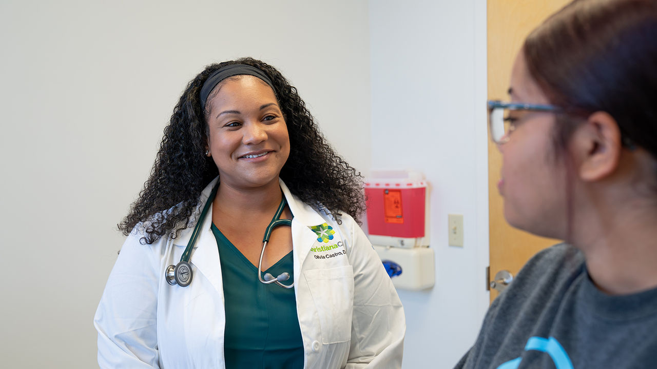 A patient speaks to a primary care provider in an examination room