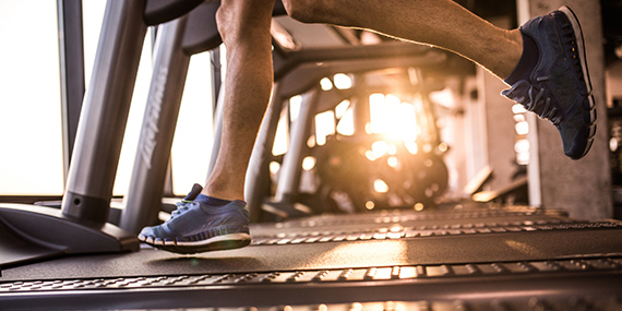 A closeup of the feet of a person running on a treadmill