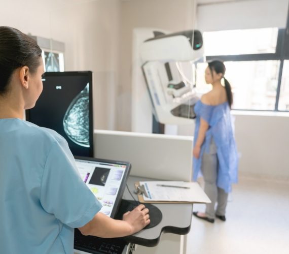 Nurse taking a mammogram exam to an adult patient