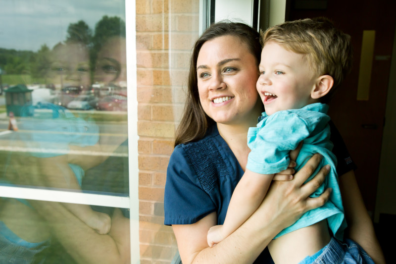 Woman with child looking out of window