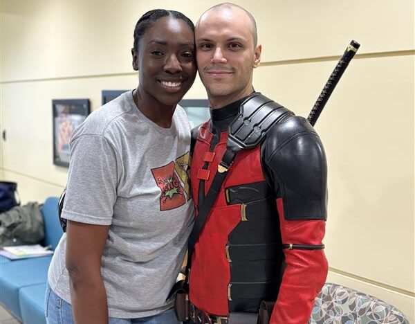 A staff member poses with a patient in a Deadpool costume during the cancer center bell-ringing celebration.