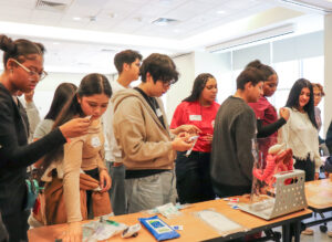 Students gather around a table for a hands-on medical activity during William Penn Career Day.