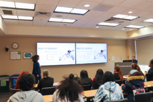 Students attend a presentation during William Penn Career Day, with a speaker at the front of a classroom.
