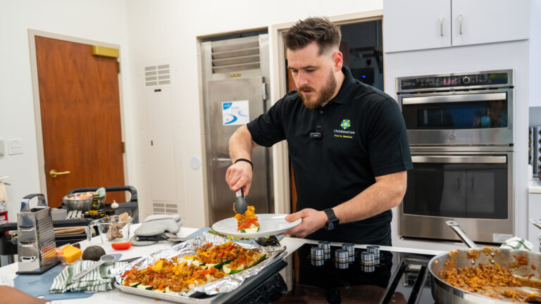 Eric Plautz serving food he has prepared