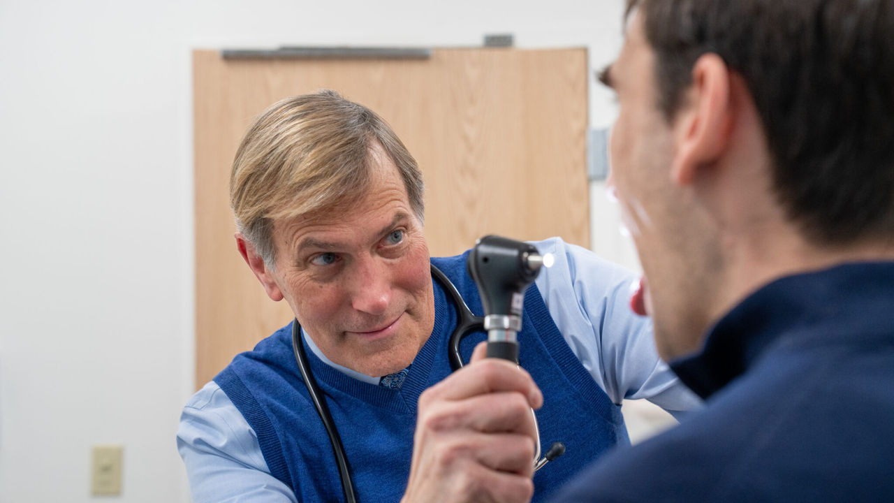 Stephen Kushner, D.O. examining a patient using a medical instrument