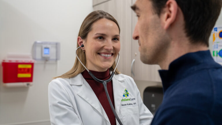 Nicole Kushner, D.O. examining a patient uisng a stethoscope