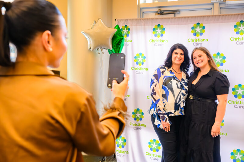 Woman photographing two winners using her phone