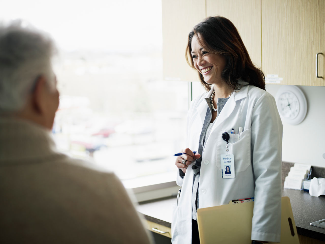 Doctor in discussion with mature female patient in medical exam room