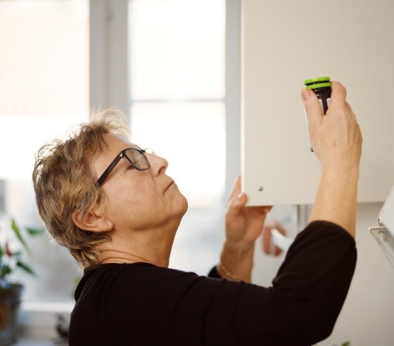 Woman looking at medication in cabinet