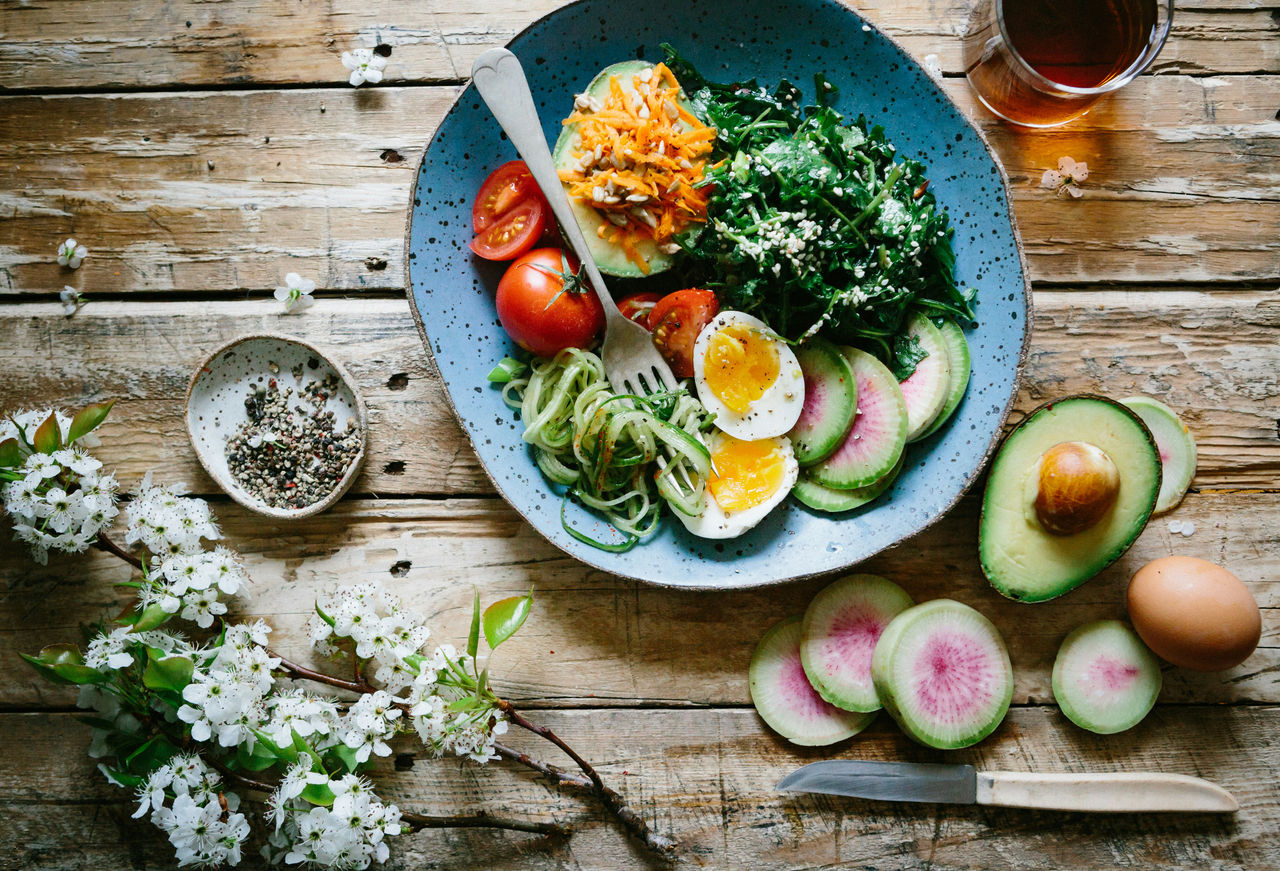 Healthy salad with avocado, soft-boiled egg, leafy greens and tomatoes