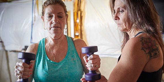 Una mujer que trabaja con pesas de mano con un fisioterapeuta