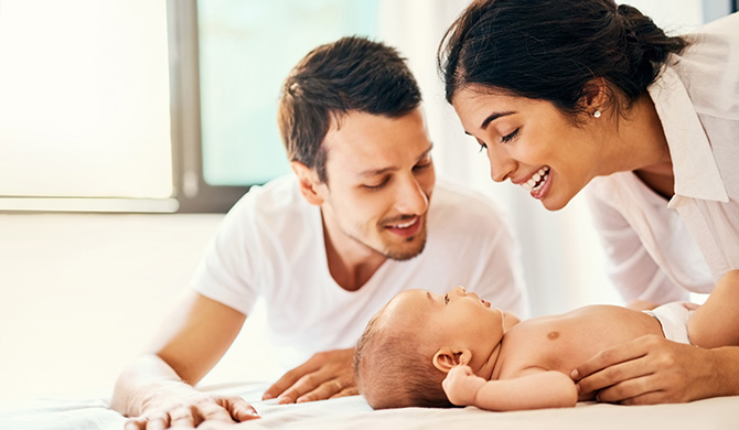 Madre y padre que sonríen con el bebé