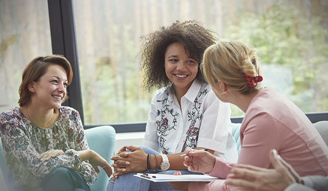 Tres mujeres conversando sentadas
